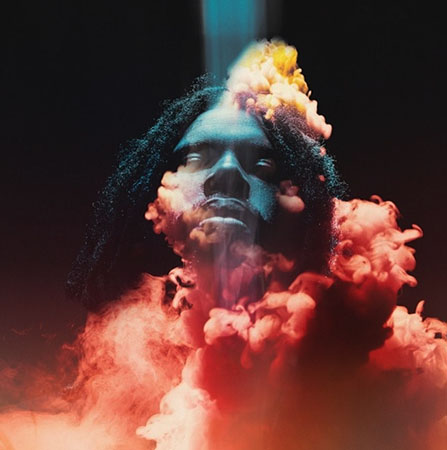 Image of artist, Flying Lotus, with a blue light casting down on hist face, that is engulfed in thick red smoke against a black background