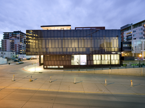 Exterior shot of the MCA Denver at dusk. The ligthing inside the museum appears to make the building glow from within. 