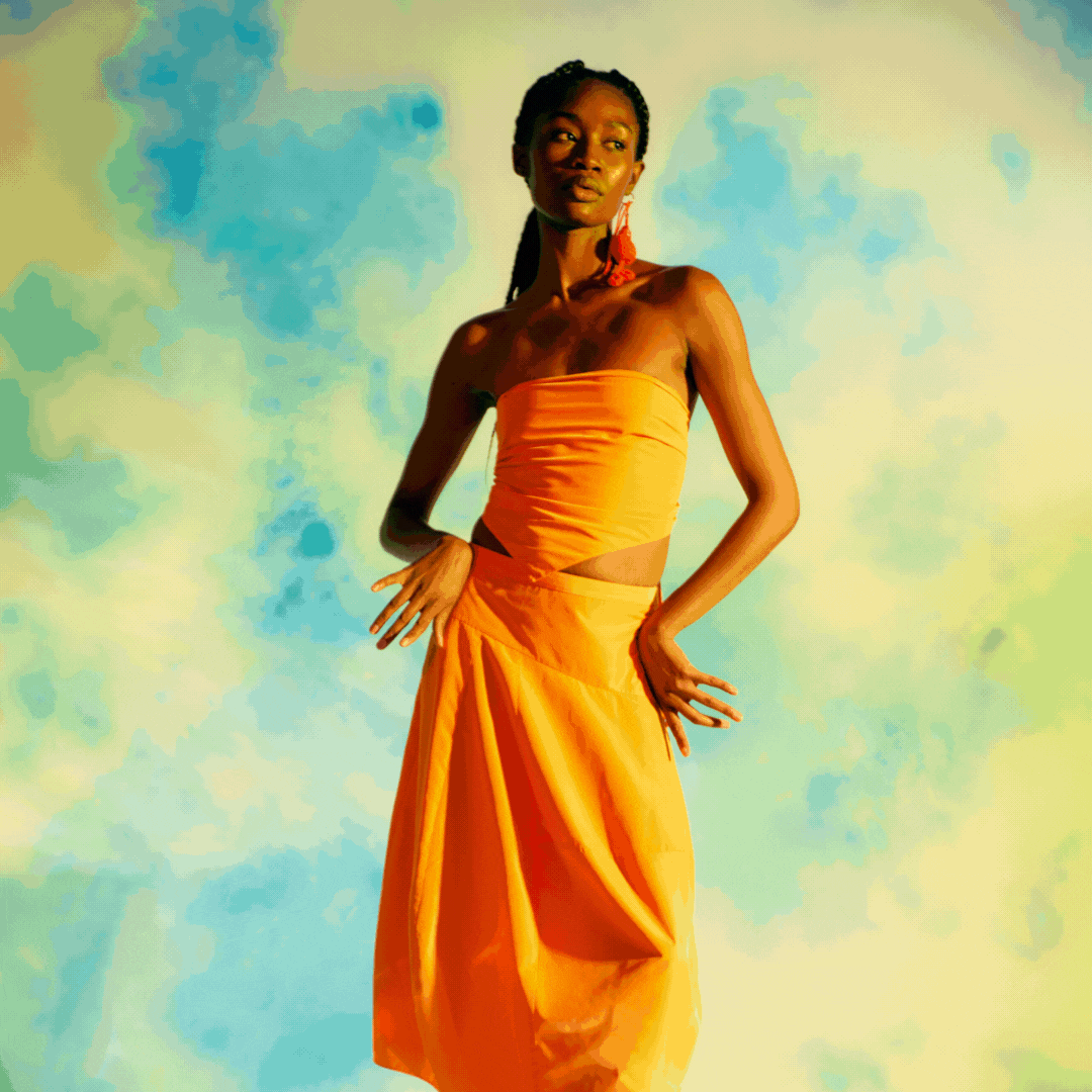 Four rotating photos of models wearing colorful outfits, set against different backgrounds: a bright but cloud filled sky backdrop, a sky at dusk, and a bright orange backdrop.