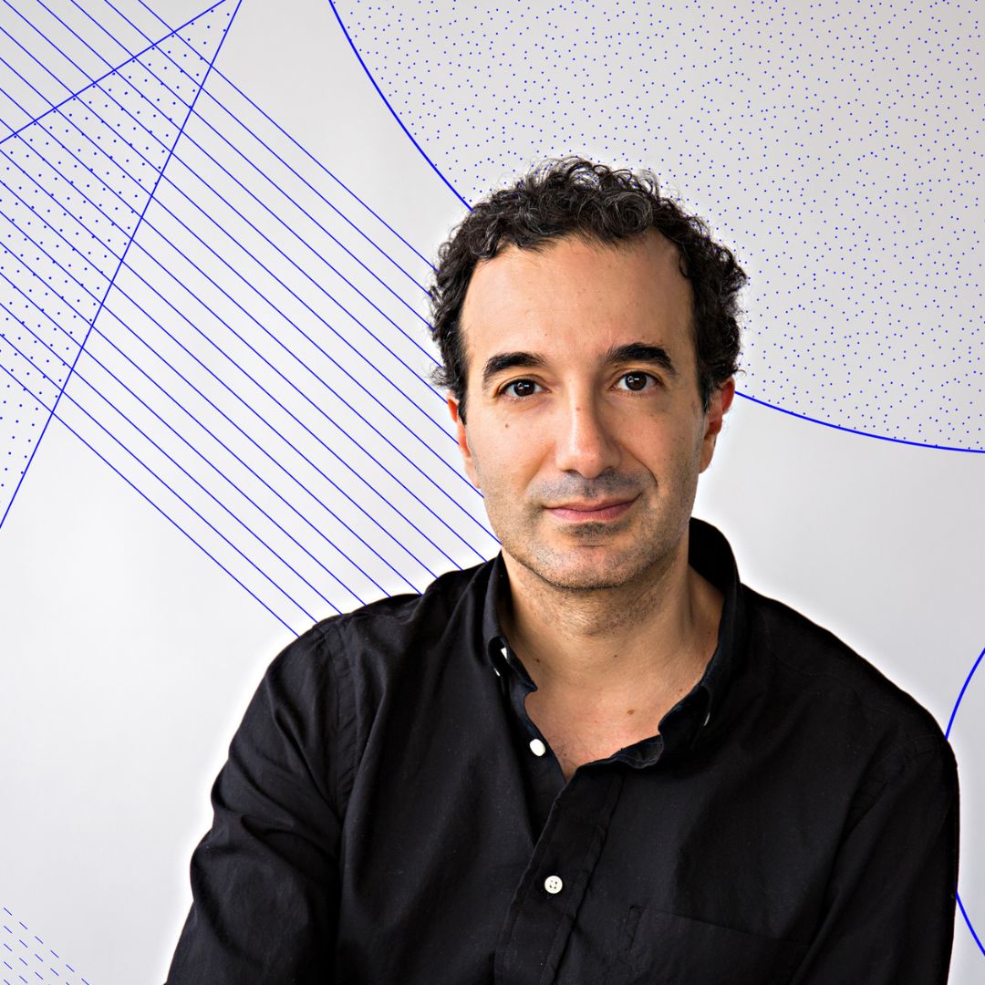 Portrait of Jad Abumrad positioned in front of a gray background with purple lines and shapes intersecting on top of the background. Jad is sporting a black button down and tousled black hair.