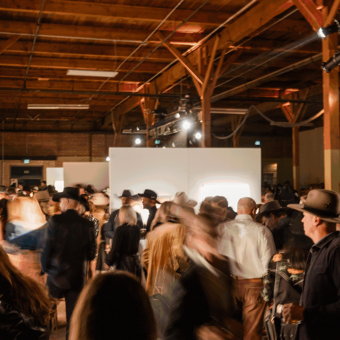 Rotating images photographed at a gala function. There are bright lights, musicians and DJs performing, people looking at art, and people smiling and mingling. Many people are wearing cowboy hats and cowboy attire.