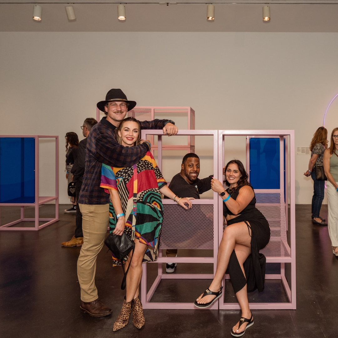 Group of people smiling in an art gallery.