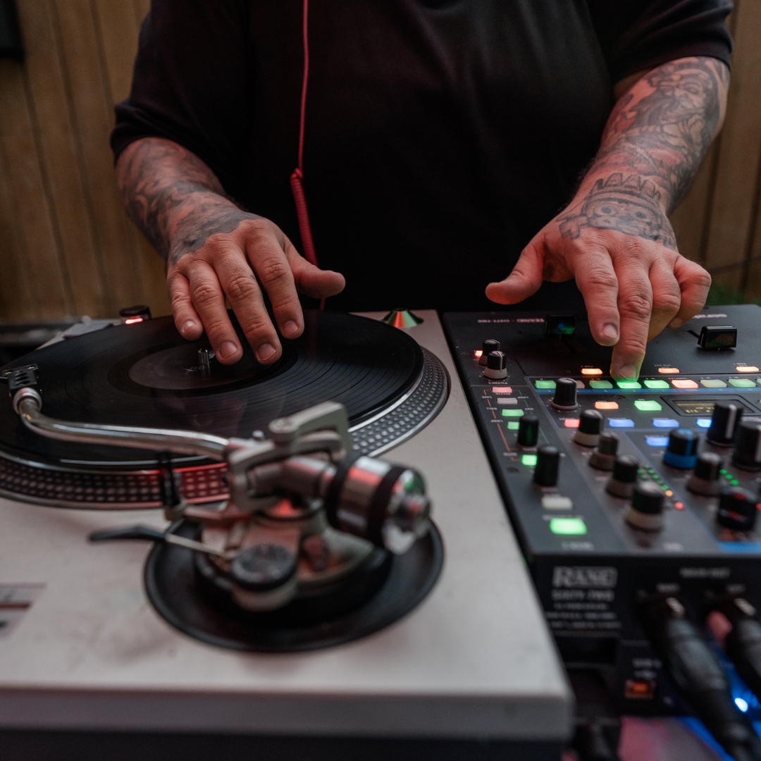 Close up of a DJ on a mixing board.