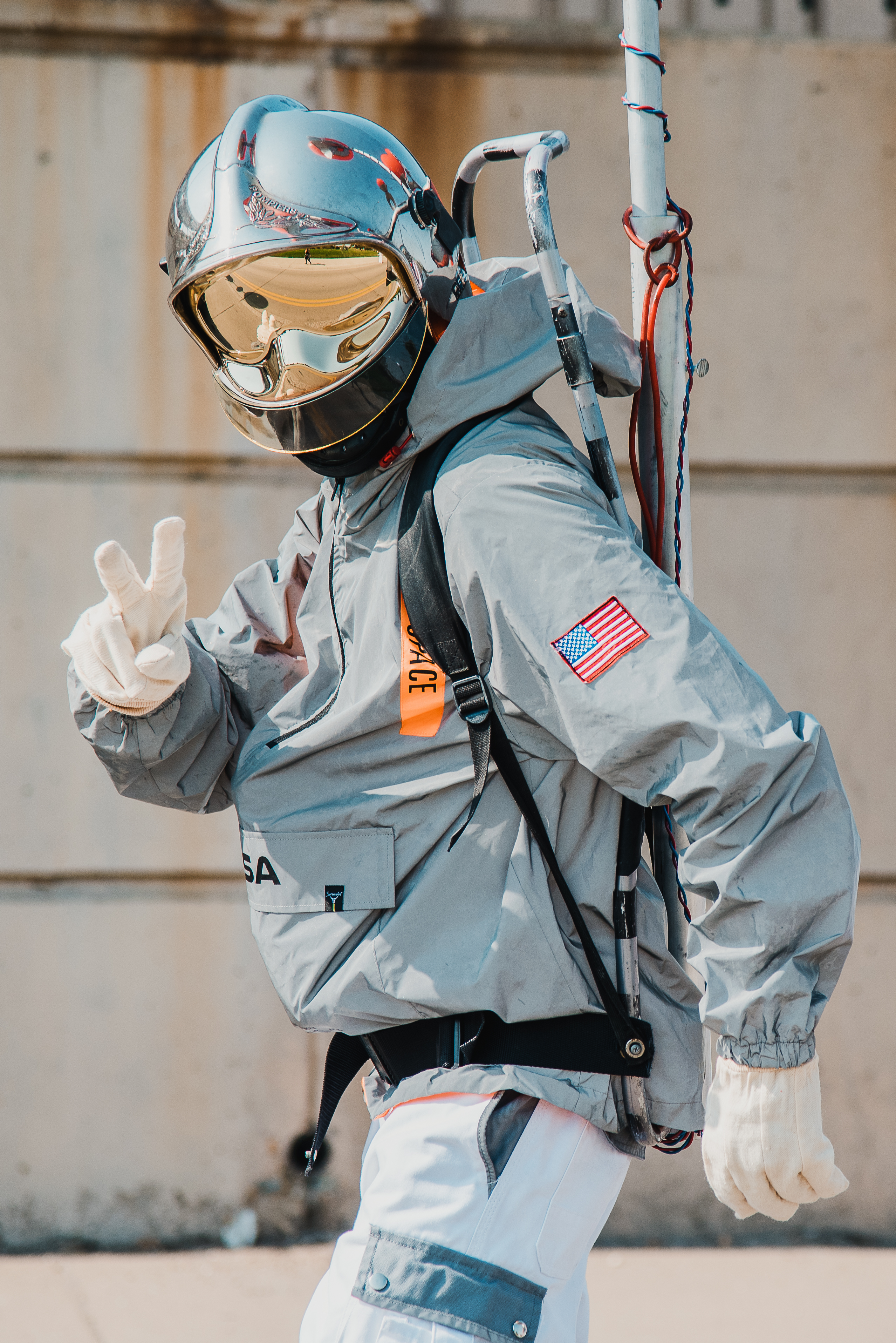 Image of a person in an astronaut costume giving a peace sign to the camera.  