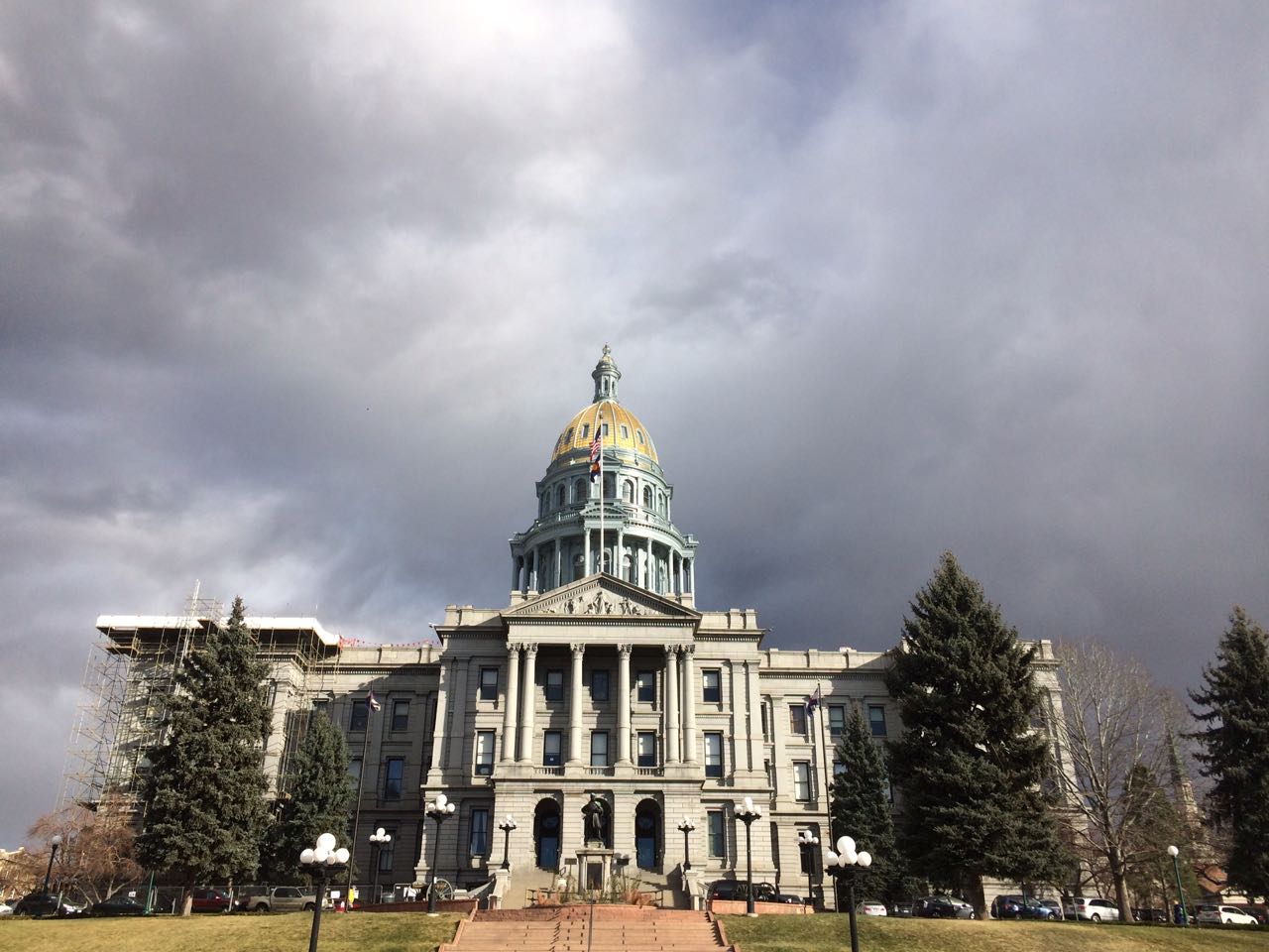 The Colorado State Capital stands against dark clouds. 