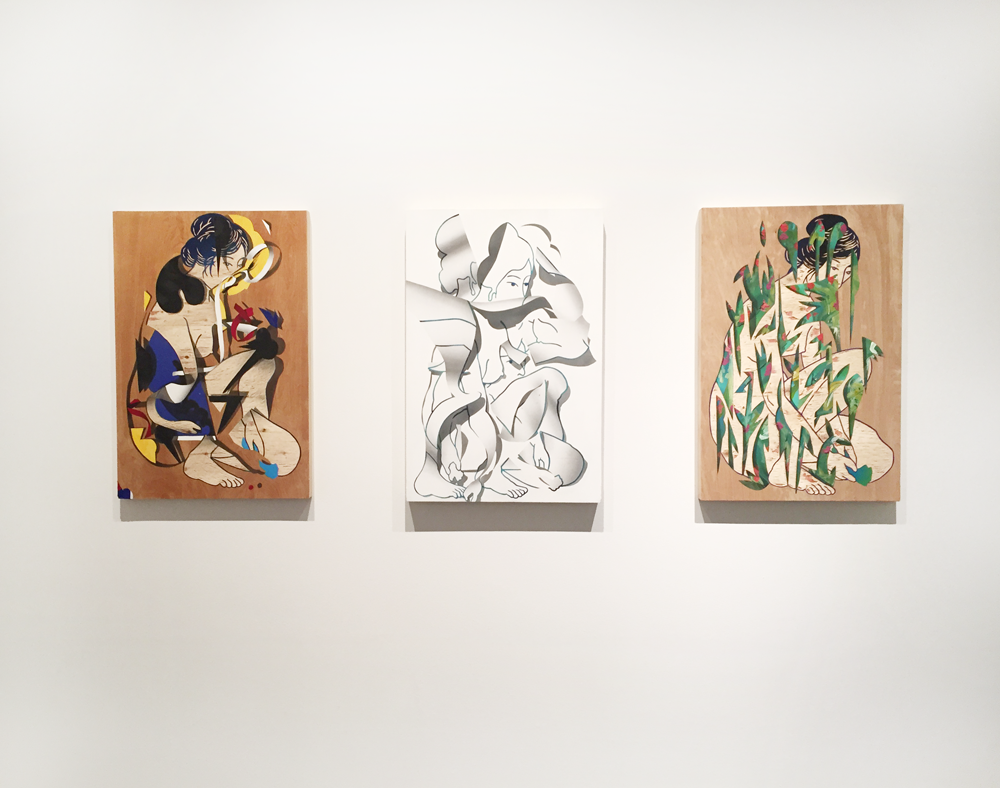 Three paintings hang on a white wall. They all depict a woman sitting cross-legged. One is in several colors; the center appears as if she is made of paper and torn apart; the final depicts her behind tall stalks of grass. 