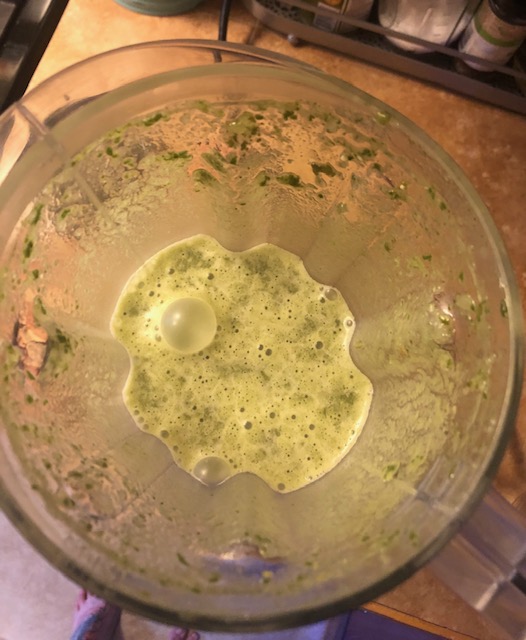 Aerial view of a blended containing blended ingredients. It’s a light green color. 