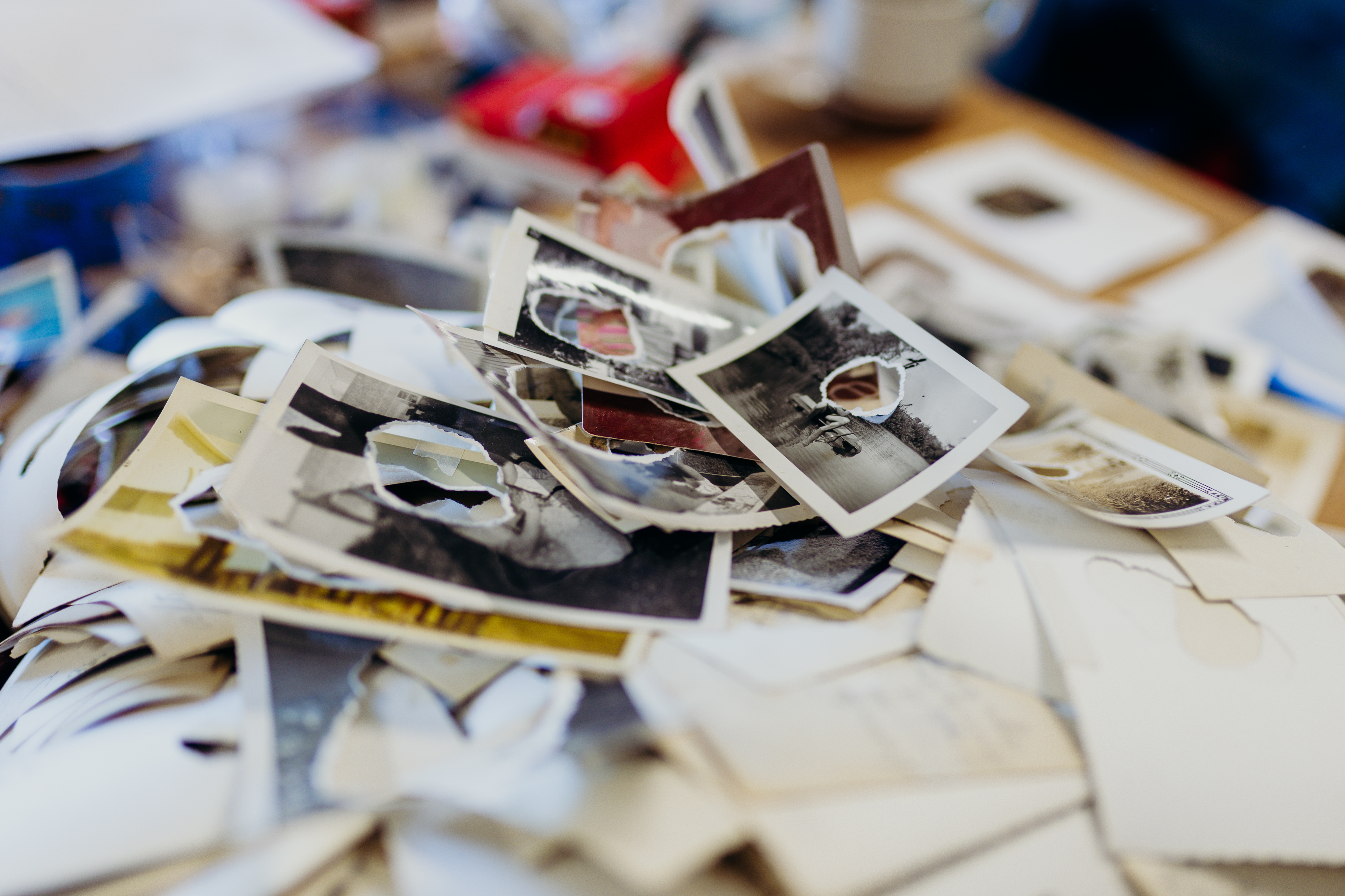 Pile of photographs with the center of them burned or cut out. 