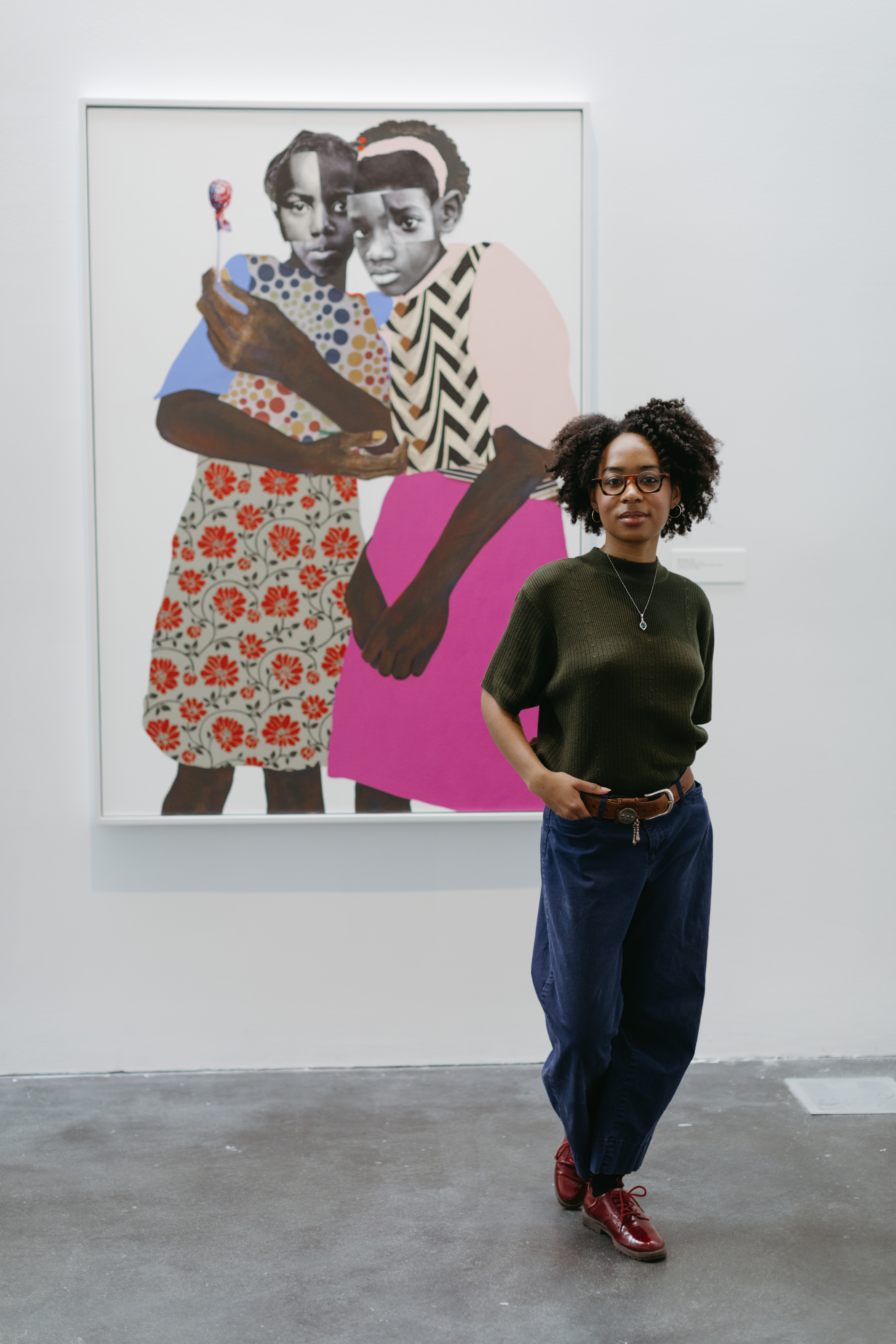 portrait of Nadiya Jackson in front of Deborah Roberts, The Unseen, mixed-media canvas portrait