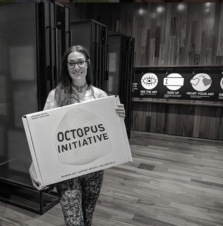 Black and white image of a woman holding a box that reads Octopus Initiative