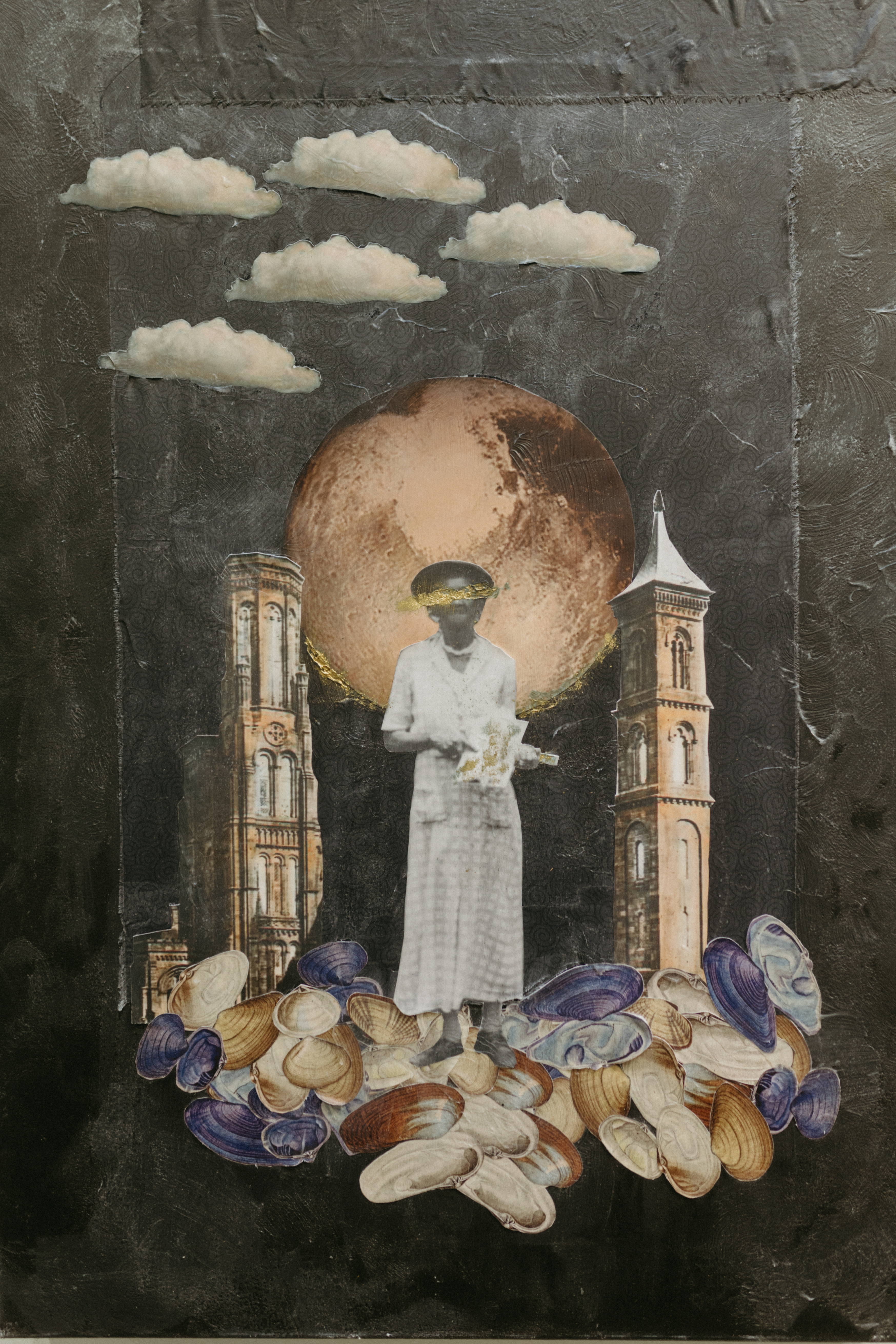 Close up image of a collage work on Anthony's studio wall. It depicts a woman standing on seashells. An image of Mars represents the large moon. 