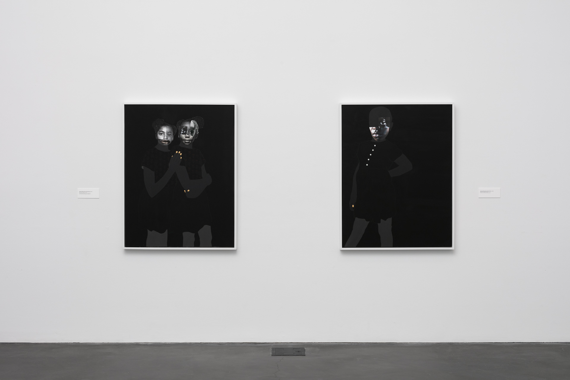 [Image description: A photo taken in the museum featuring two mostly black paintings hung on the wall side by side. The paintings feature black backgrounds with collages of young Black girls.]