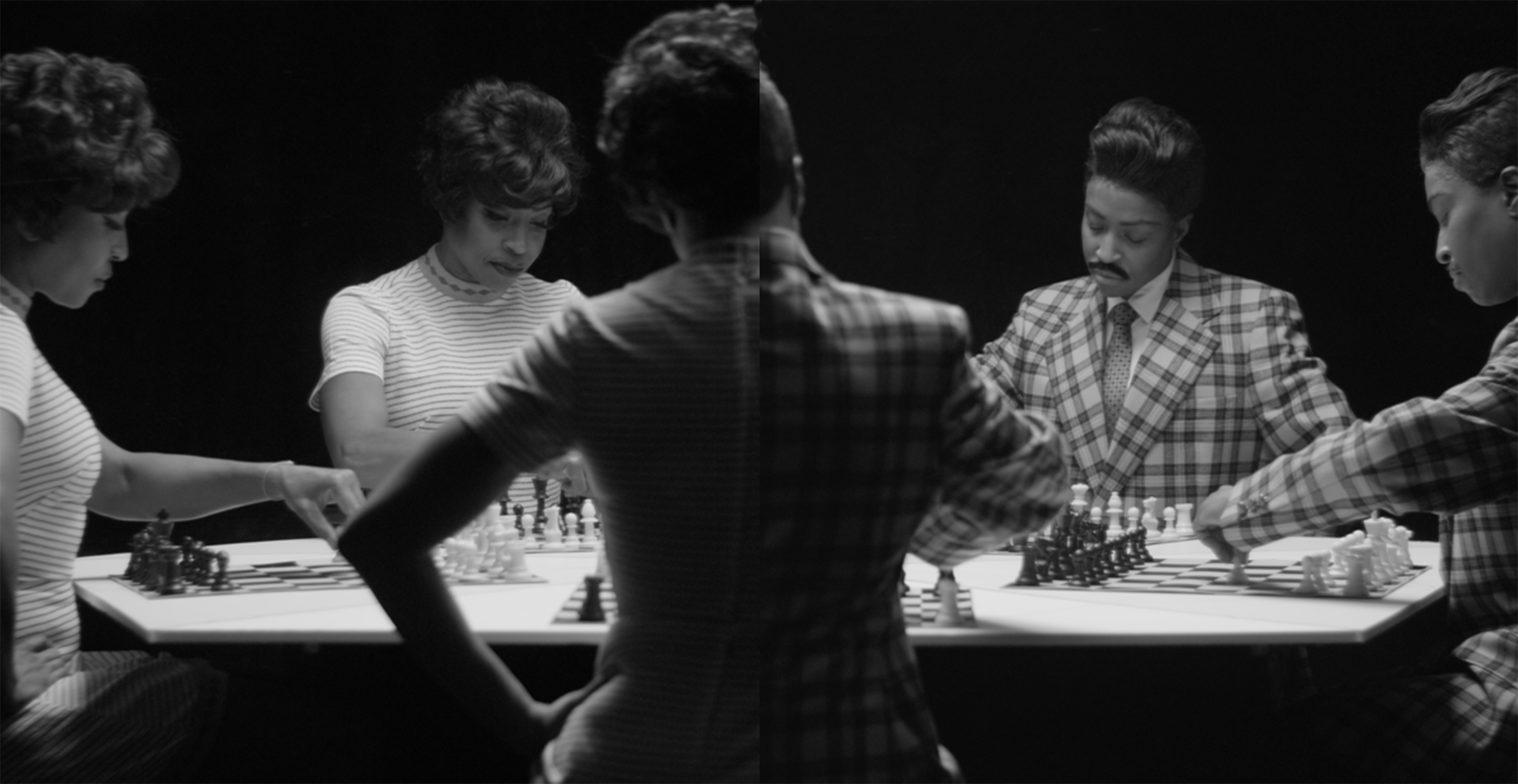 [Image description: A black and white still from the film Chess by Lorna Simpson. In the image, Lorna is seen five times playing against herself in a game of chess. Three of the Lornas are dressed as a woman and in the other two, as a man.]
