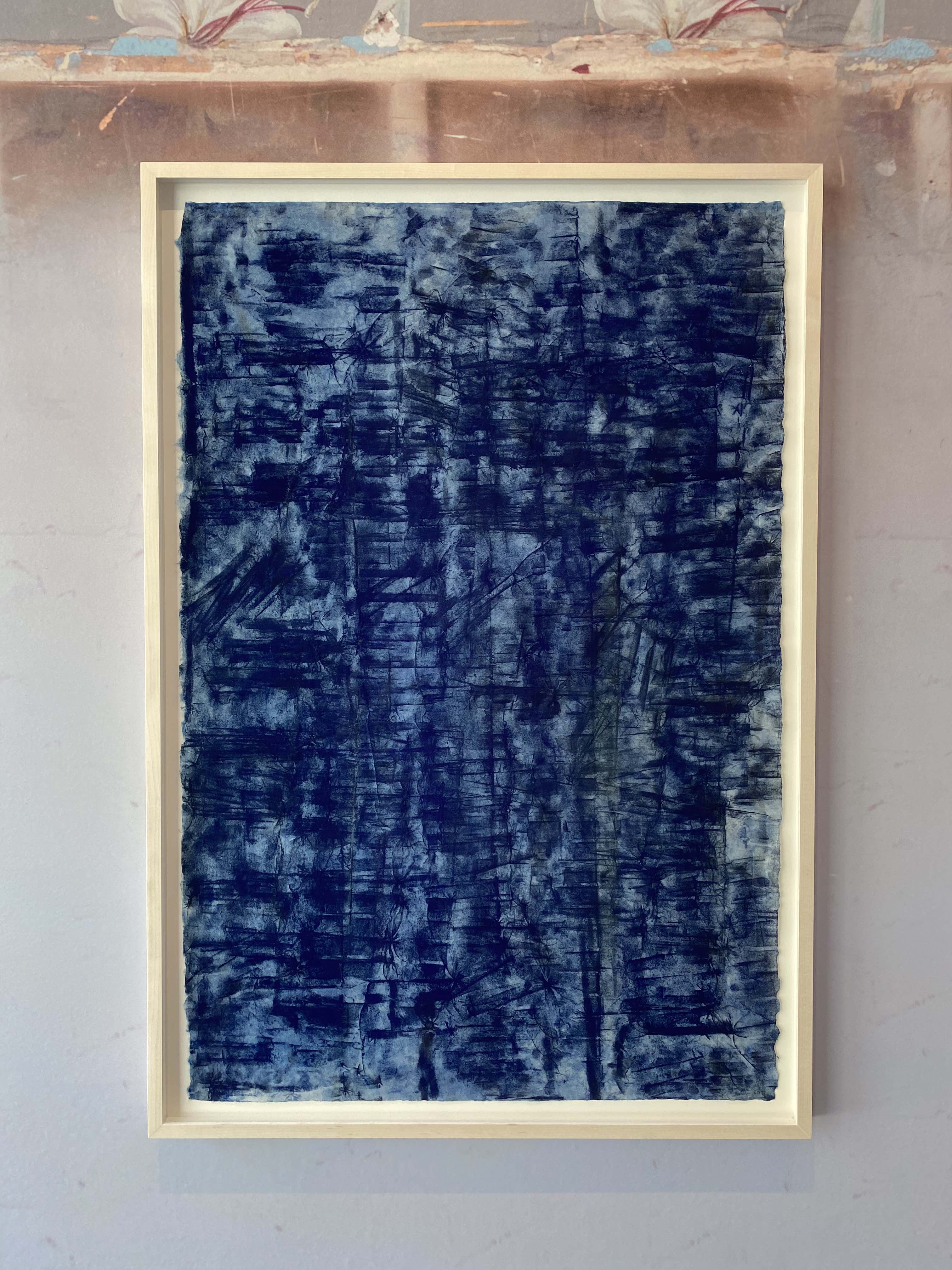 [Image description: A photograph of a work by Jason Moran hung on a wall. The painting features dark blue dashes overlapped on top of each other on white gampi paper. The painting is hung in a white frame.]