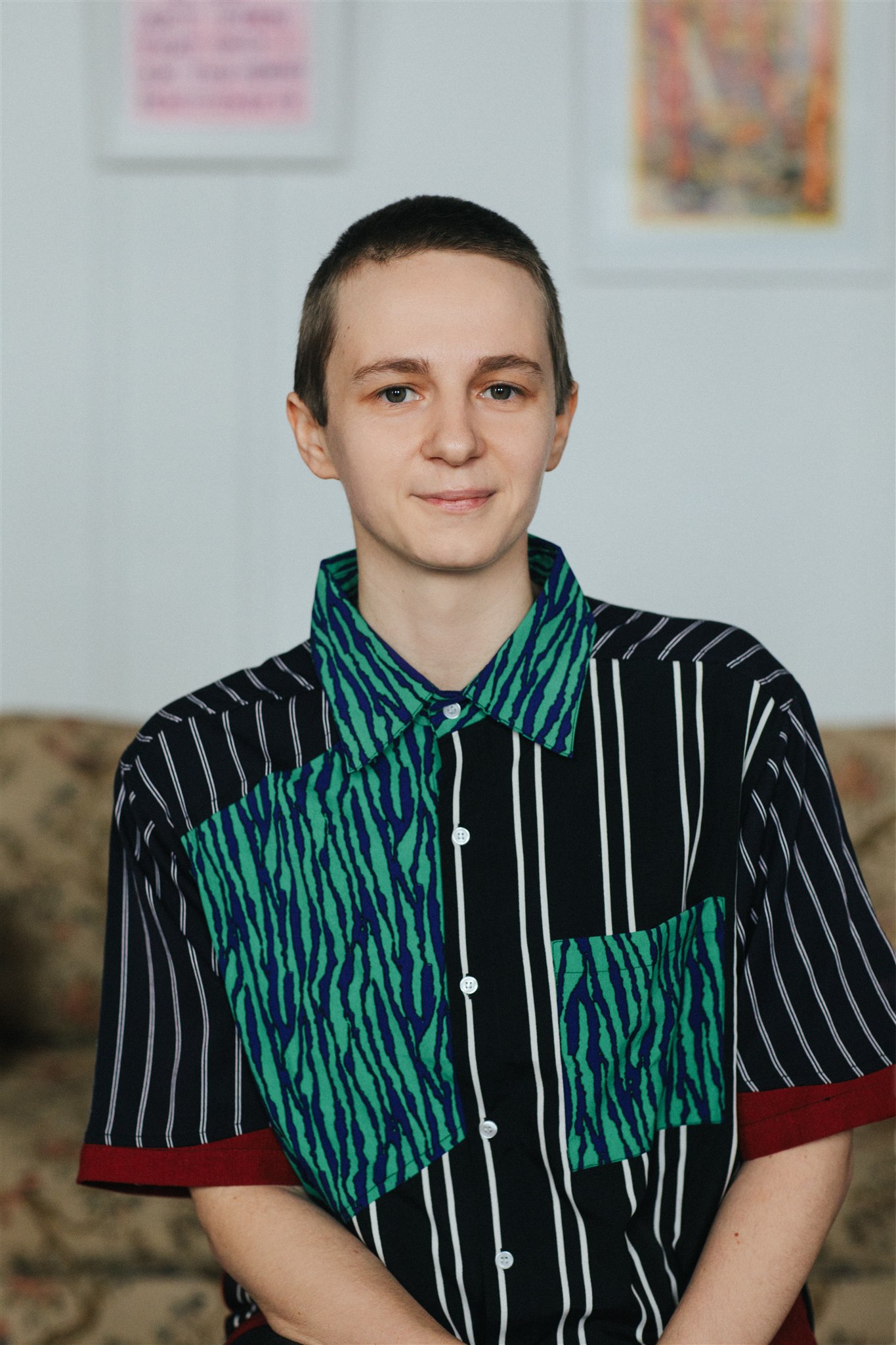 Portrait of Shannon Finnegan wearing a button down collared shirt with blue and great tiger stripe patterns, and and blue and white pinstripe patterns.