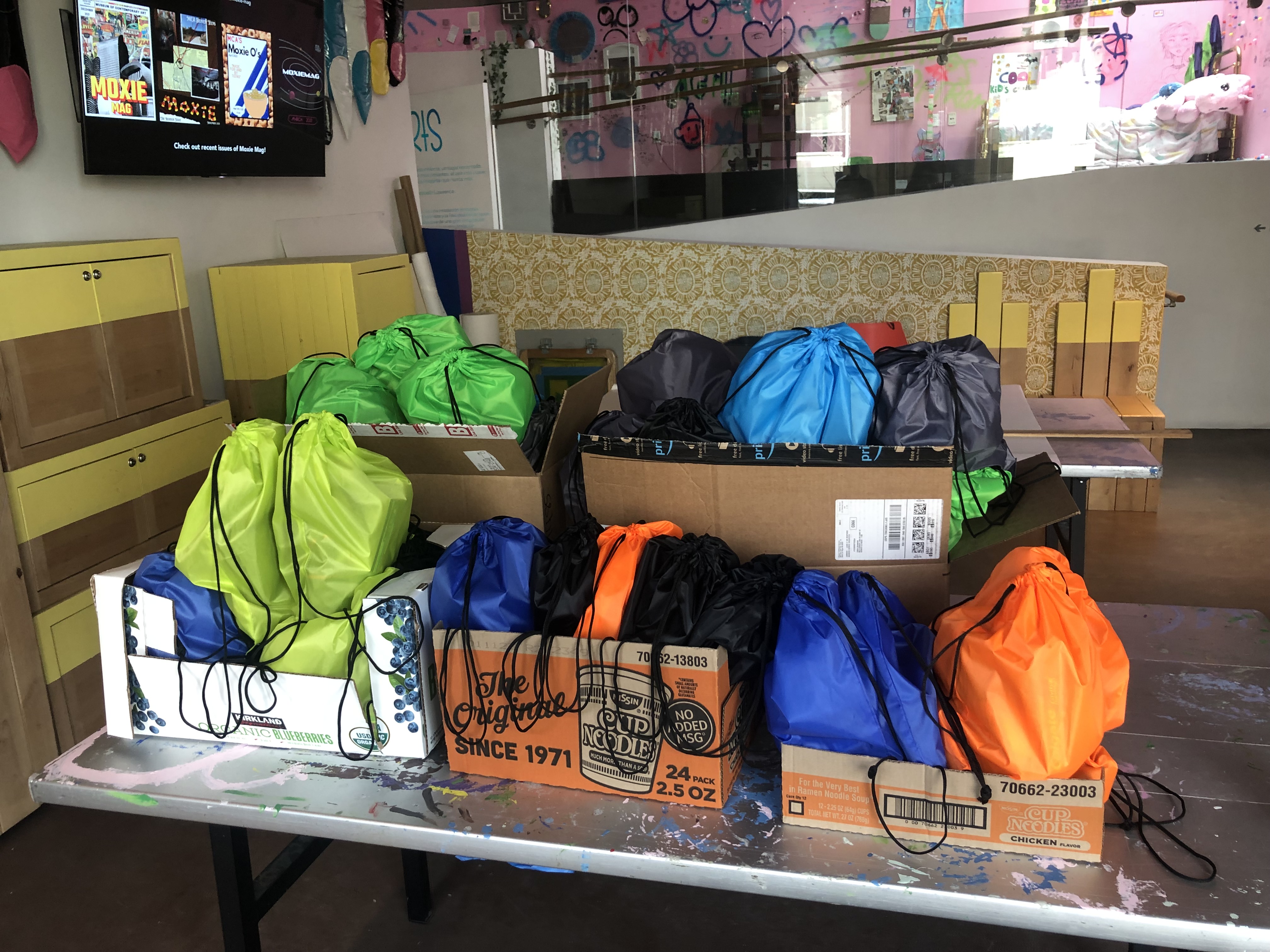 Colorful drawstring bags in a cardboard boxes.