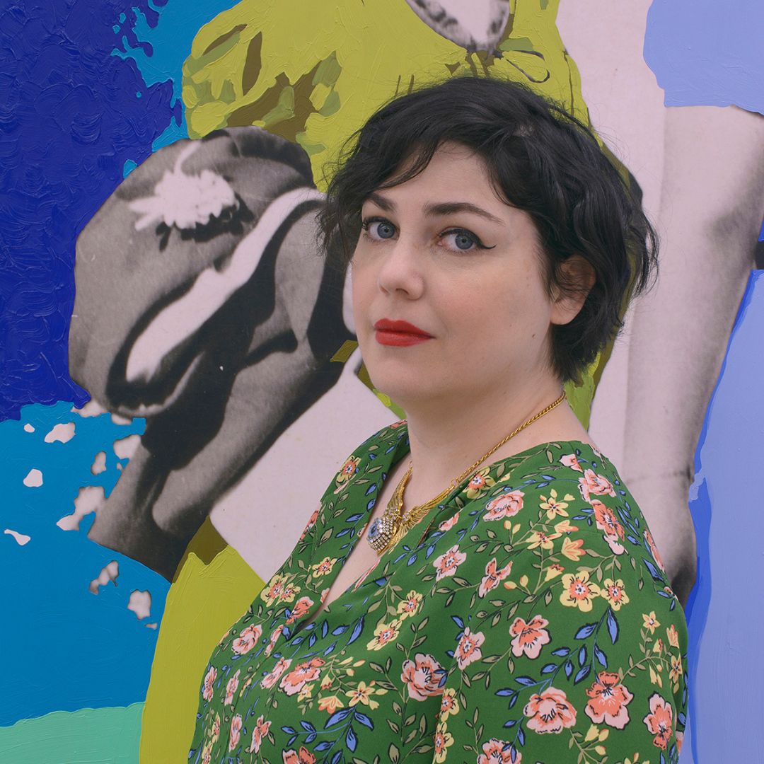 Portrait of artist Daisy Patton sporting a colorful, floral top and standing in front of a colorful artwork.