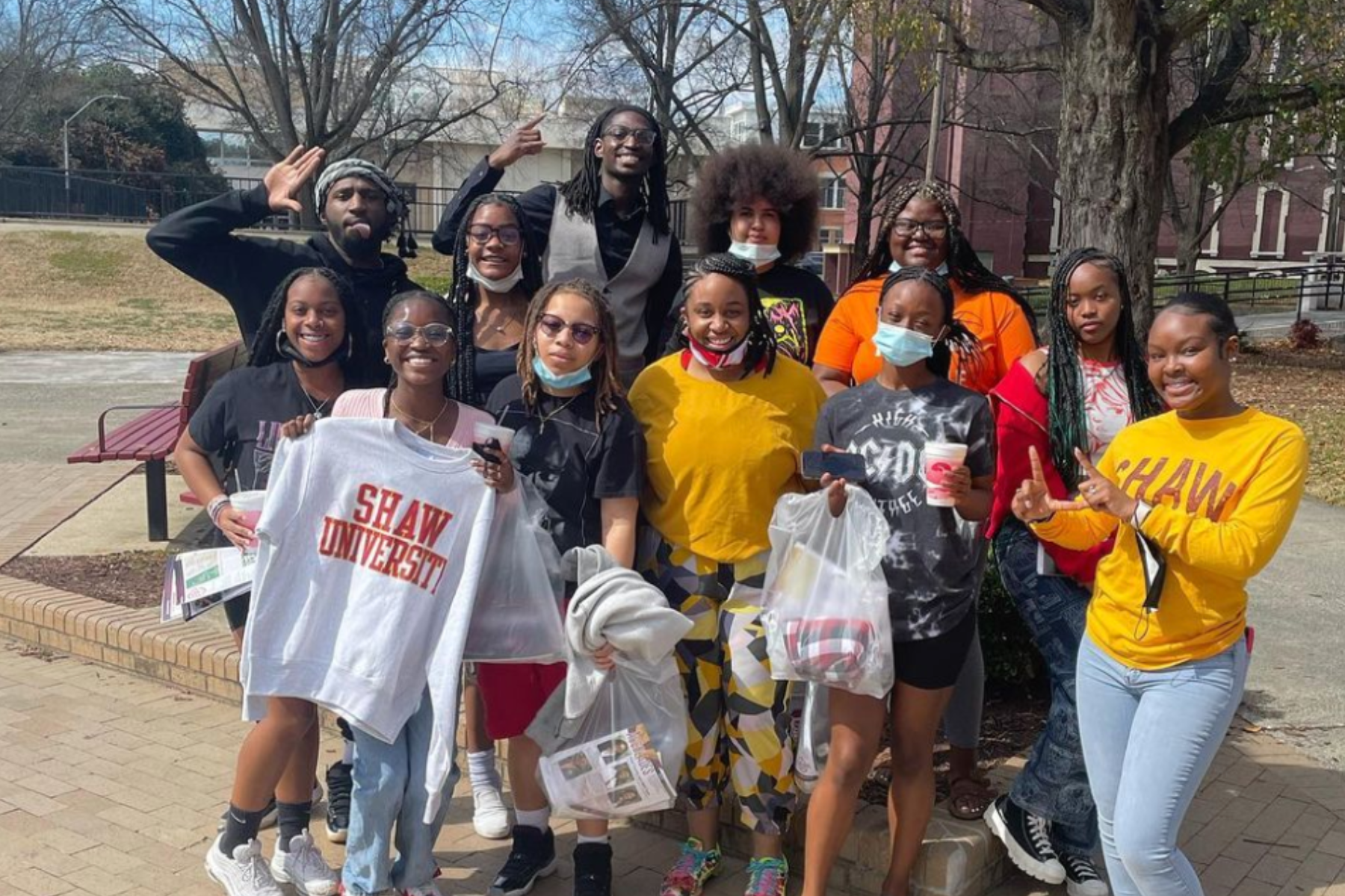 Denver East High School’s Black Women’s Unity Club standing close together and posing for a photo. They are standing outside near large trees.