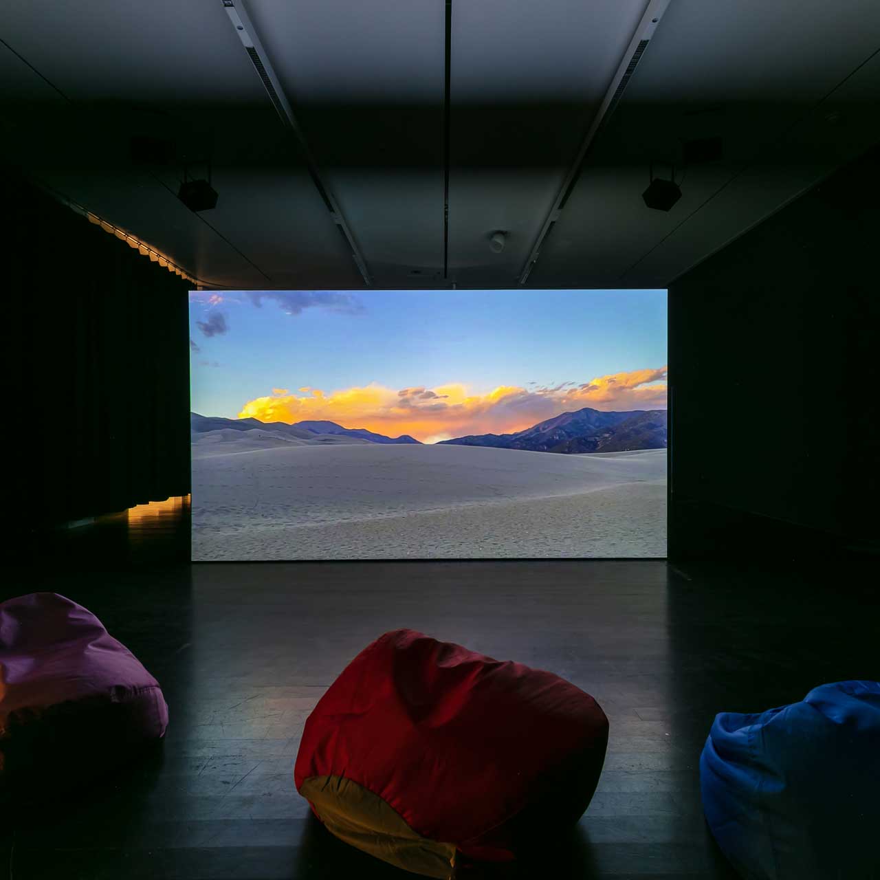 Video projection with bean bags around it. 