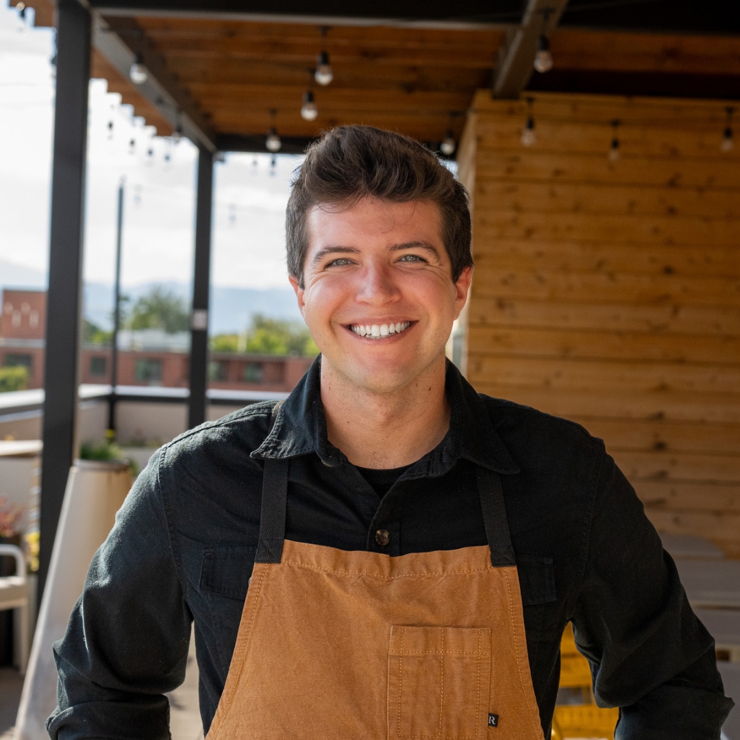 Chef  Jonas Zukosky smiling and wearing a brown apron. 