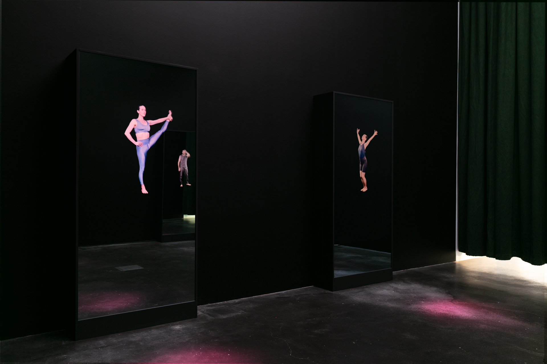 Dark gallery featuring screens depicting people in yoga clothes holding different poses.