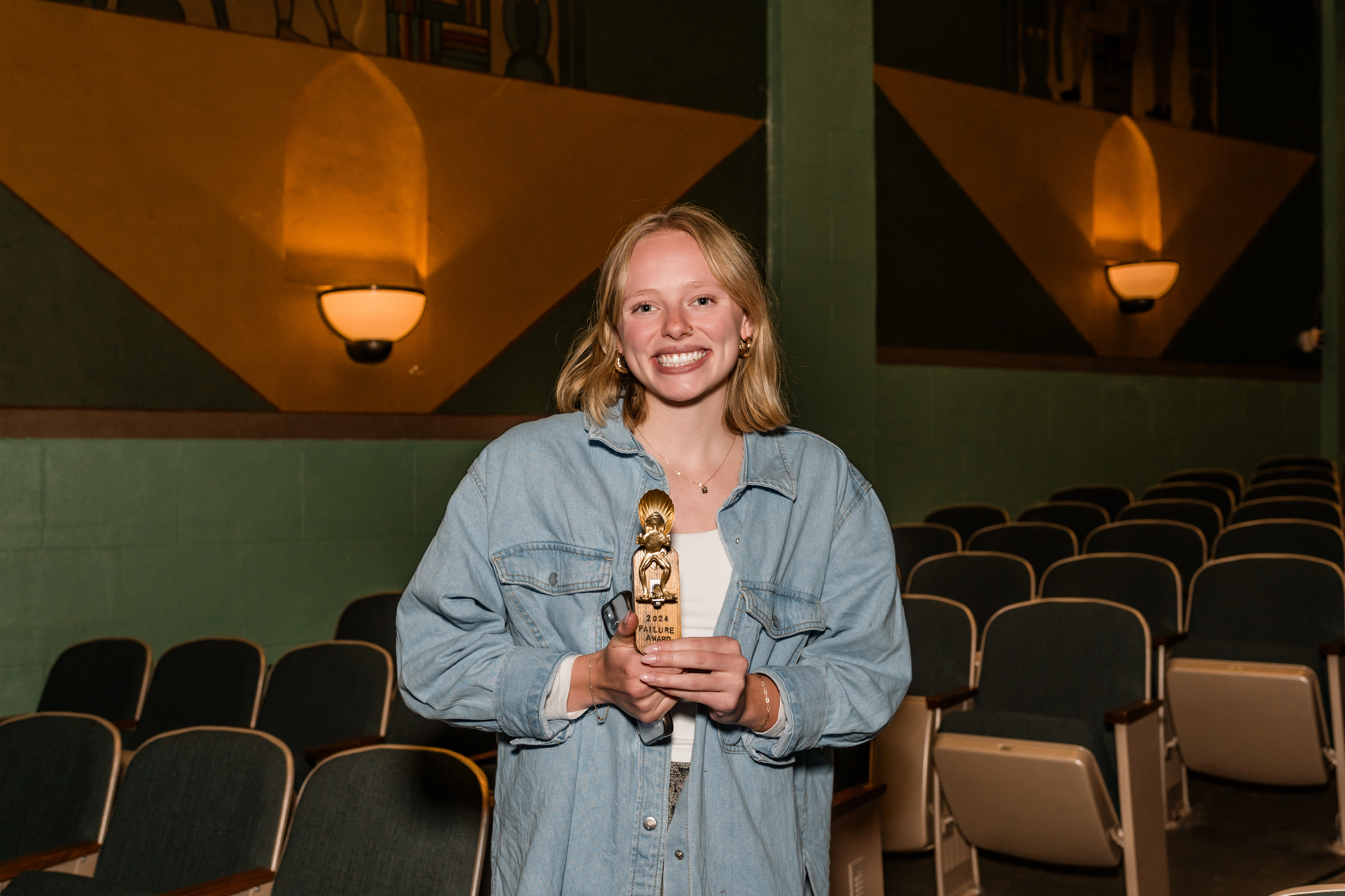 High school senior Josie Wilson holding a trophy in a theater.