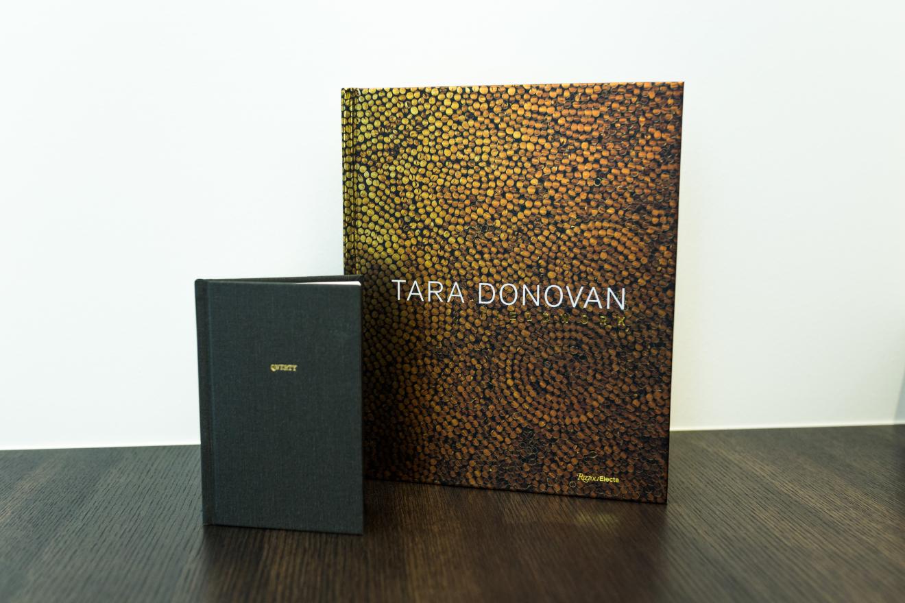 Two books. One is small and black and is titled QWERTY. The other features tara Donovan's name against a golden pattern. 