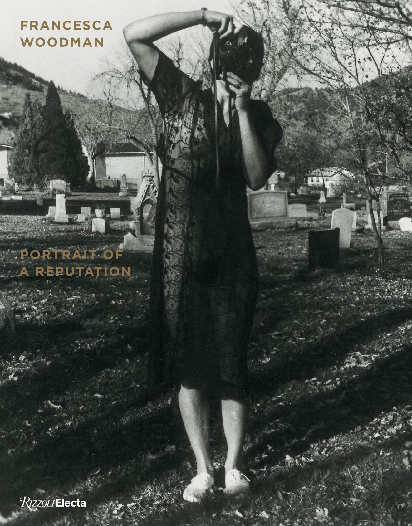 Francesca Woodman: Portrait of a Reputation, Exhibition Catalogue. A woman is standing in a graveyard in a sheer black dress. She is holding a camera up to her face at an angle. 
