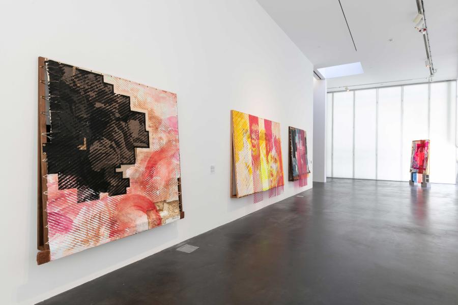 An MCA Denver gallery with large, colorful abstract artworks on the walls and on the floor in the corner of the space.