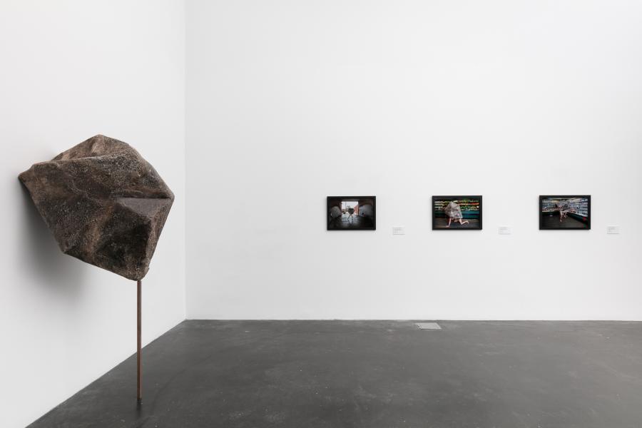 MCA Denver gallery showing a boulder-like sculpture affixed to the wall and three works of art hung on an adjacent wall. 