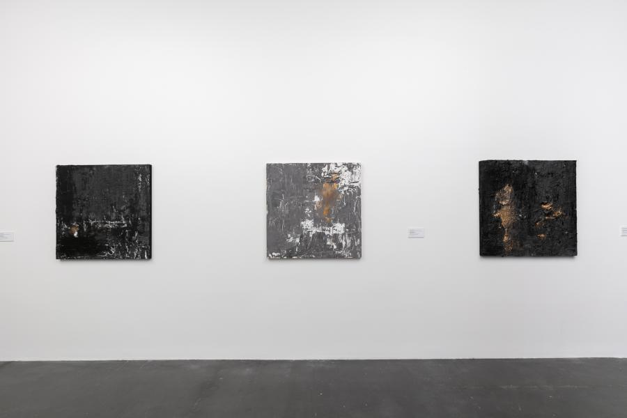 Three artworks made of plaster, textile, fabric, acrylic on wood panel. The works are abstract and layered, and consist of deep black and orange colors.