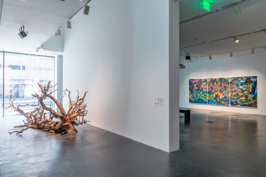 Gallery featuring a large tree. The gallery adjacent shows a large colorful painting. 