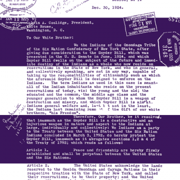 A white laser print on double-sided fleece blanket, that looks like a letter. It has two thick purple horizontal stripes on it. It is addressed to Calvin Coolidge. 