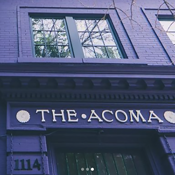 Purple brick building with the words "The Acoma" above the entrance.