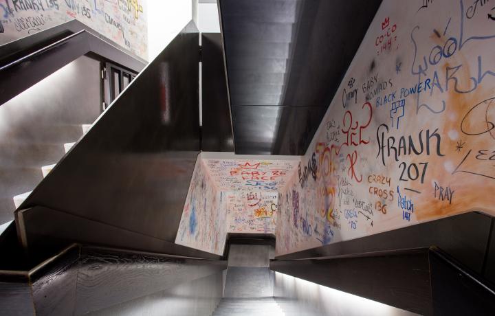 Photo of a stairwell covered in vinyl resembling wall graffiti. 