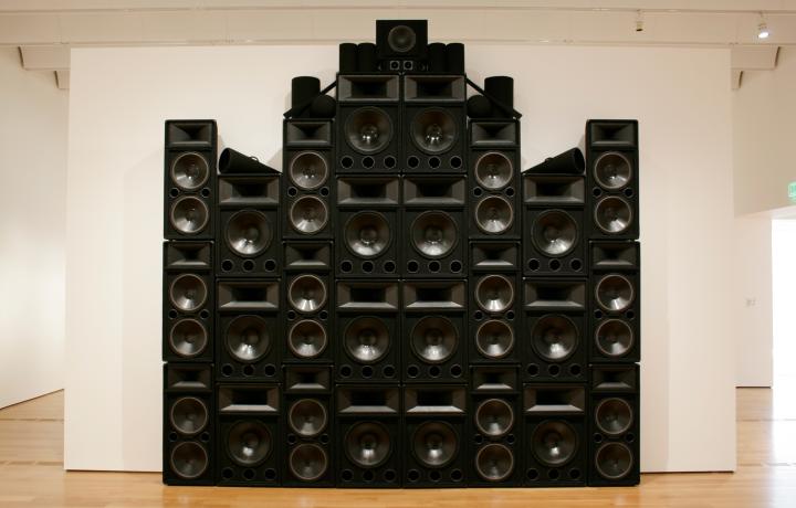 Large installation of black speakers stacked on top of one another