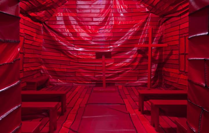 Red vinyl, hand sewn installation is in the form of an early 20th Century Black church