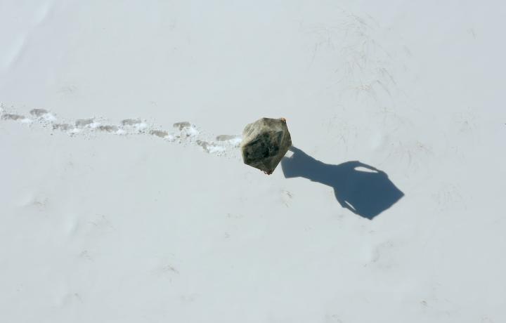 Bird’s eye view of a boulder being carried in the snow.