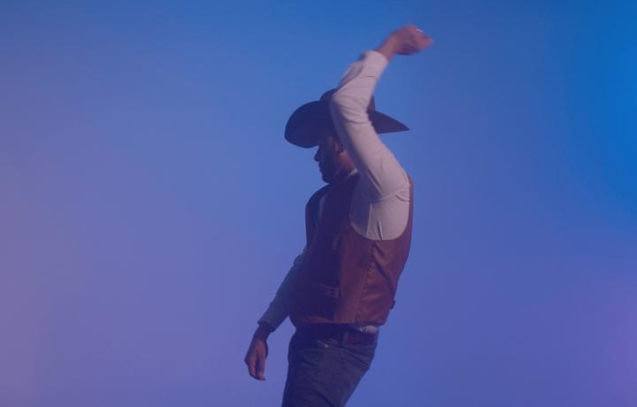 Cowboy photographed against a blue sky.