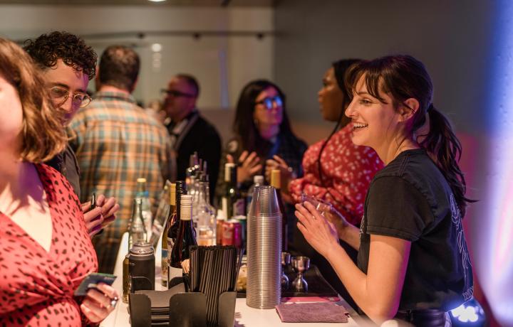 Bartender serving patrons in a crowded space.