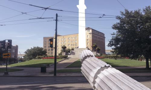 Image of an newly imaged Confederate monument falling down leaving a blank space in the sky where the monument once was 