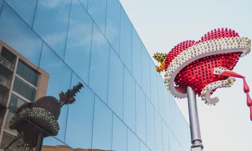 The sculpture titled “Toxic Schizophrenia / Hyper Version” outside the MCA Denver building. The sculpture features a heart and blood dripping from a jeweled dagger, which pierces the heart. The heart is made of fiberglass and LED lights.