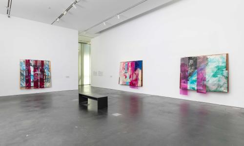 Three large, colorful, abstract artworks hung on white walls in an MCA Denver gallery.