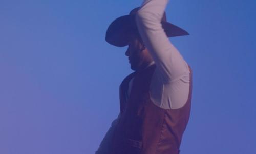 Cowboy photographed against a blue sky.
