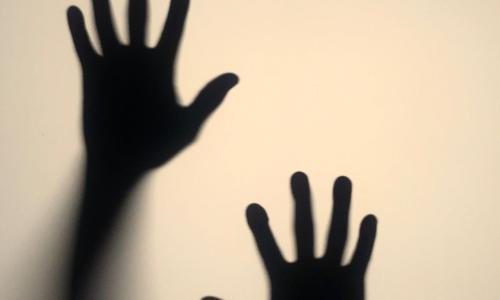 Creepy photo of hands up against glass.