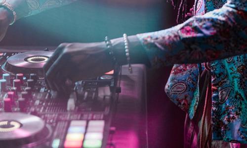 Close up of a DJ on a mixing board.