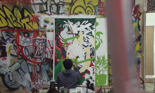 A man is working on a large abstract painting. 